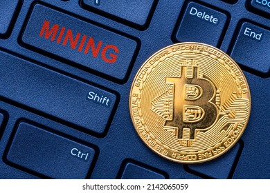 Golden bitcoin and keyboard with text MINING. Cryptocurrency mining concept.