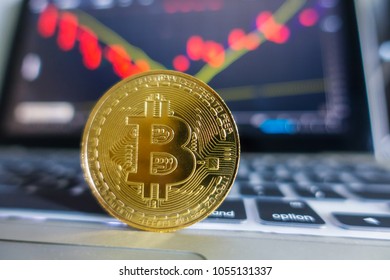 Golden Bitcoin laptop keyboard with stock exchange graph background. Digital money concept. 