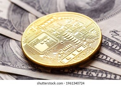 Golden Bitcoin lies on the banknotes.New virtual money. Crypto currency top view. Real coins of bitcoin on banknotes of one hundred dollars. Exchange, commercial. online business concept.