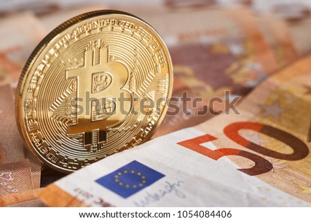 Golden bitcoin on fifty euro banknotes background. Bitcoin crypto currency, Blockchain technology, digital money, Mining concept, bitcoin on 50 euro bill. Macro