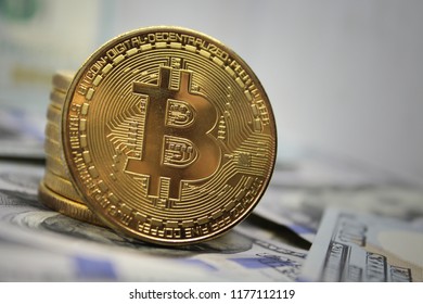 Golden bitcoin on hundred dollar bills background.Bitcoin cryptocurrency, BTC.Virtual money.Electronic money exchange concept