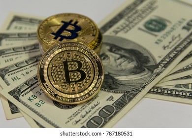  golden bitcoins  on background of one hundred dollar bills
