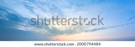 Golden Blick of the sunset on the lilac-blue sky. A sky pattern to replace the sky in the photos. Sunset idyll of calm sky. Natural cloud backrop with gradients and glow.
