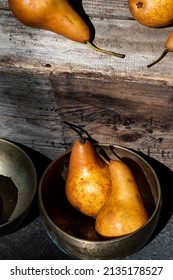 Golden Bosc pears on vintage wood crate and in brass bowls