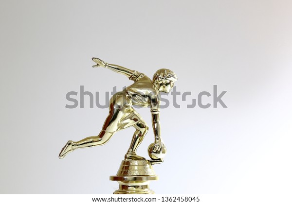 Golden bowling award cup over white\
background for bowling champion. Gold bowling\
trophy