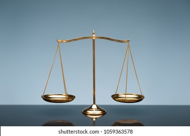 Golden Brass Balance Or Imbalance Scale On Blue Color Background. Weight Balance. Symbol Of Law Justice, Libra, Decision, Crime, Financial.