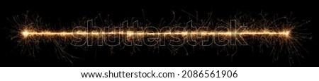 golden bright sparkler wide panorama tracer fuse line isolated on dark black background. anniversary, pyrotechnics, wedding and happy birthday celebration party concept
