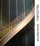 Golden bronze vintage looking Spiral Staircase Stripes Against a blue green striped Wall at Orpheum Theater in downtown Phoenix Arizona USA Maricopa County vertical diagonal lines design movement  