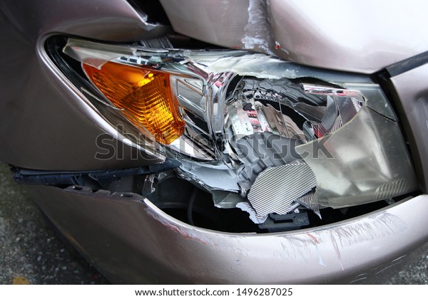 Golden brown\
car\'s front light is broken. Crashed car destroyed automobile part.\
Insurance of car crash is\
important