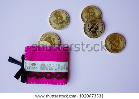 Golden btcoins outof a pink wallet