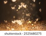 Golden butterflies light glitter, magical sparkling scene. Sparkling Glitter butterflies background, magical gold and black wallpaper. Butterflies and gold sparkles on black background wallpaper