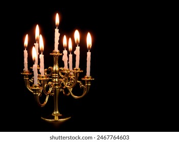 Golden candelabra with white burning candles isolated on black background.	Copy space for text. - Powered by Shutterstock