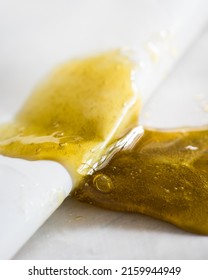 Golden Cannabis Rosin On Parchment Paper. Neutral Background.