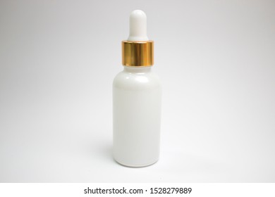 Golden Cap Serum Bottle On A White Background