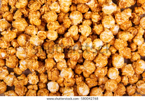 Golden caramel popcorn closeup. Background of\
popcorn. Snacks and food for a\
movie