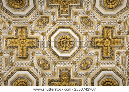 Golden ceiling with intricate geometric patterns, crosses, and floral designs, in a space inside St. Peter's Basilica