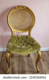 Golden Chair With Green Tufted Velvet, Against A Pink Background