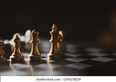 Golden Chess game King,Queen,Bishop staying on board,Business planing strong concept with dark background.