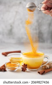 Golden Cinnamon Turmeric Milk. Golden milk with species turmeric, cinnamon, honey and ginger on grey background. Trendy hot Healthy drink. Indian Garam Doodh.
