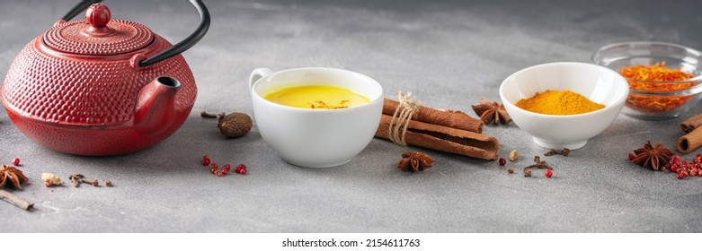 Golden Cinnamon  Turmeric Milk. Trendy hot Healthy drink with turmeric roots and spices. Indian Masala Haldi Doodh. Wooden background. Top view