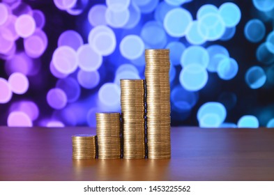 Golden coin stacks arranged as a graph. Increasing columns of coins - Shutterstock ID 1453225562