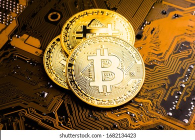 Goldene Münzen mit Bitcoin-Symbol auf dem Mainboard.