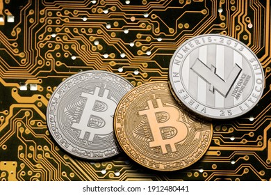 Golden coins with bitcoins symbol on a mainboard.