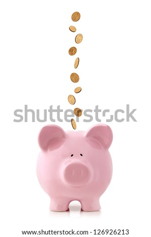 Golden coins falling into a pink piggy bank, isolated on white.  US dollar coins