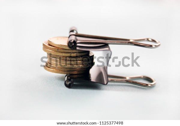 golden coins tightened up in a clamp,\
financial crisis concept or inflation, austerity, budget control\
conceptisolated, on white\
background.