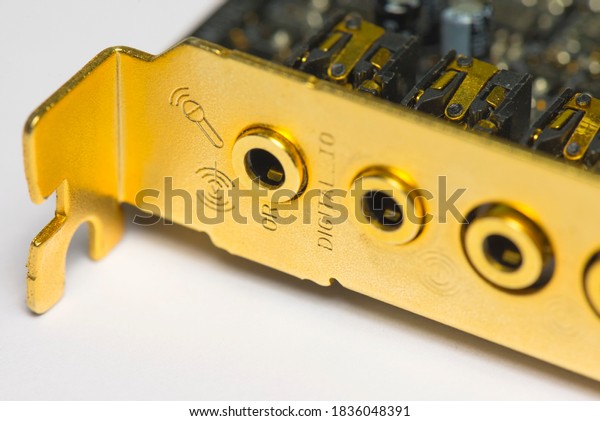 Golden computer sound card panel with input and\
output audio ports. Professional computer device for good quality\
sound.