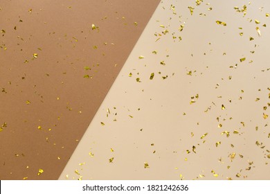 Golden Confetti On Earthy Brown, Beige Paper Geometric Trendy Background. Festive Holiday Backdrop. Birthday Congratulations Christmas New Year. Flat Lay, Top View, Copy Space.