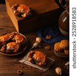 Golden crabs and mooncakes sit artfully on a rustic wooden table, accompanied by aromatic ginger and decorative pottery.