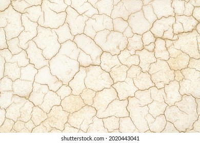 Golden Cracked desert soil. Arid climate. Dry dewatered sandy ground. Abstract texture or background. Horizontal format.