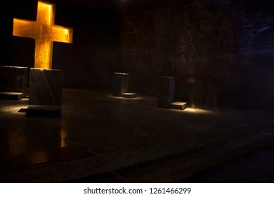 
Golden Cross With Reclinatories In The Background With Salt Formations In Its Structure In The Cathedral Of Salt In Zipaquira Colombia