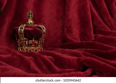 Golden crown on a red velvet background