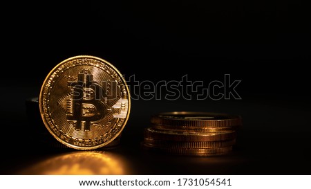 Golden cryptocoin Bitcoin BTC with reflection and another coins on the black background