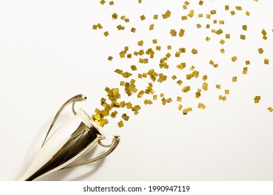 Golden Cup And Explosion Of Confetti On The Light Background