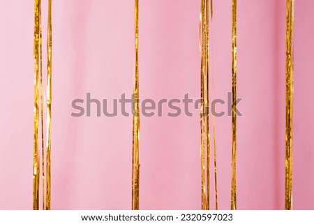Golden curtain rain fringe on pink background. Concept of Valentine's day, birthday, mother's day in barbiecore style