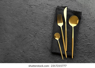 Golden cutlery on black background - Powered by Shutterstock