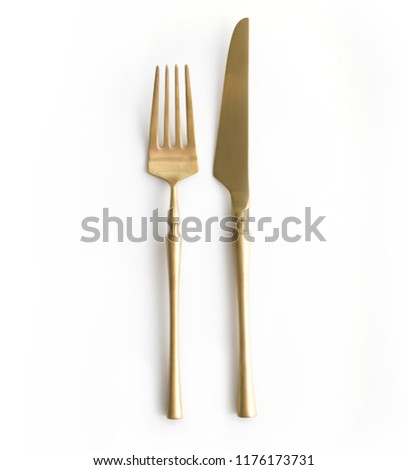 Golden cutlery view from above on a white background. Top view.
Knife and fork for a festive table for a wedding, birthday or party.