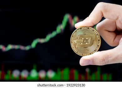 Golden Dash cryptocurrency coin with candle graph background, Crypto is Digital Money within the blockchain network, is using technology and online internet exchange. - Shutterstock ID 1922923130