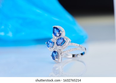 
Golden diamond ring sapphire stone blue background
