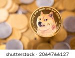 The golden Dogecoin with background of regular coins. Dogecoin cryptocurrency symbol