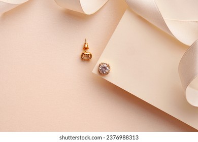 Golden earrings on paper background studio shot