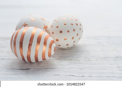 Golden Easter Eggs On White Wooden Rustic Vintage Background.