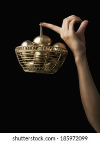 Golden Egg Basket Hanging From Finger