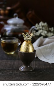 Golden Egg With A Crown On A Wooden Table