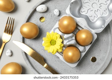 Golden eggs on table with fork and knife