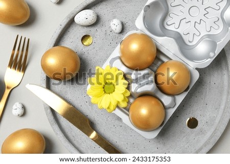 Golden eggs on table with fork and knife