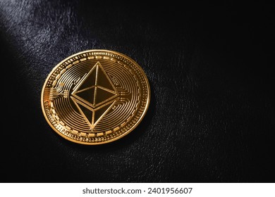 Golden Ethereum is an asset of choice for many investors, close up Golden Ethereum ETH coin , Ethereum ocin crypto currency on black leather and bright light background.
